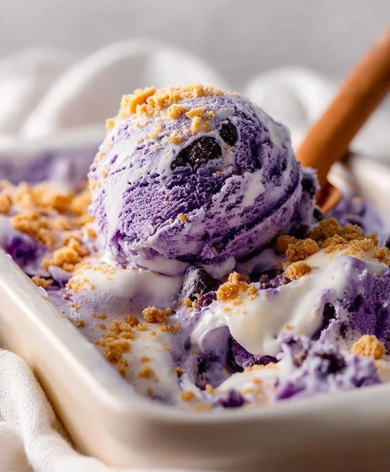 A bowl of creamy blueberry ice cream topped with fresh blueberries
