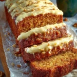 Healthy vegan carrot cake loaf with walnuts and carrots on a wooden table.