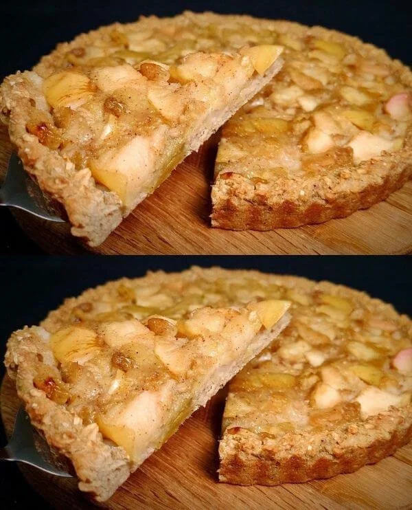 Healthy apple oatmeal pie with oats and sliced apples on a rustic wooden table.