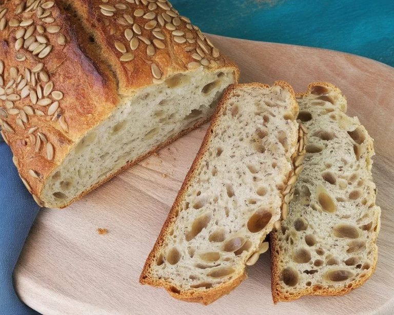 A slice of crispy protein seed bread with seeds and nuts, highlighting its rich texture.