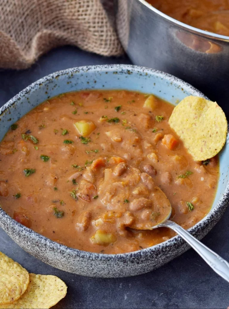 Bowl of delicious homemade Pinto Bean Soup garnished with herbs.