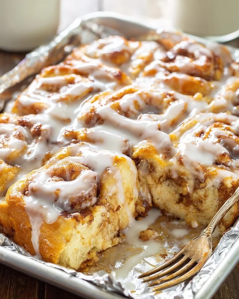 Delicious Pumpkin Cinnamon Roll Casserole topped with creamy frosting