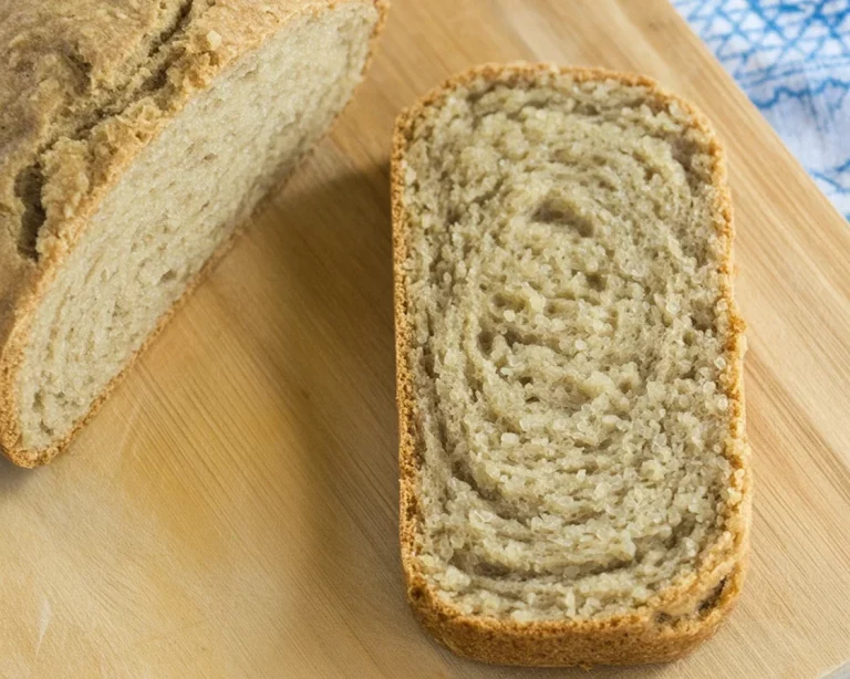 Slice of high-protein quinoa protein bread with chia seeds on a wooden board