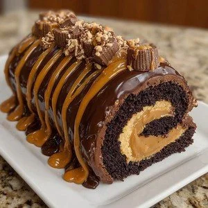 Peanut Butter Cup Chocolate Roll Cake with creamy frosting and peanut butter cups