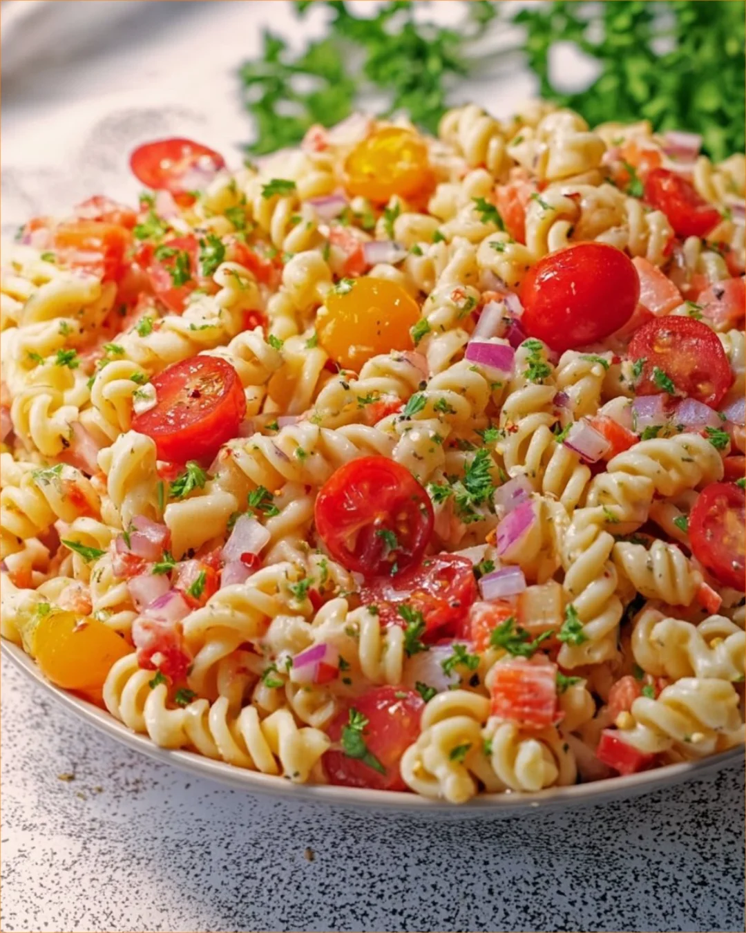 Bowl of homemade Amish Macaroni Salad with colorful vegetables and dressing.