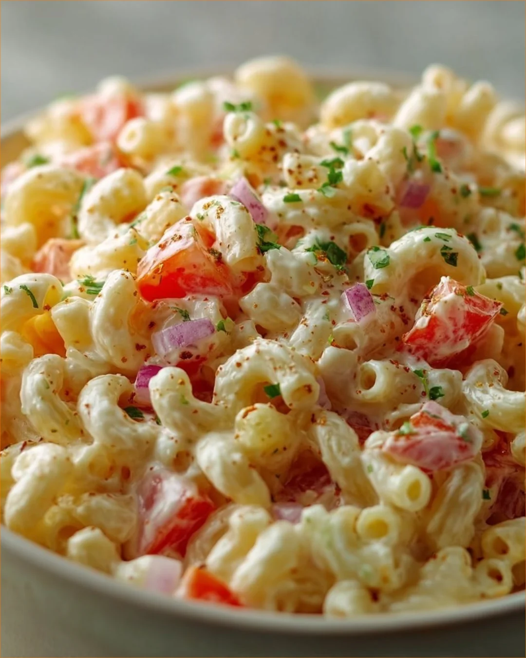 Bowl of homemade Amish Macaroni Salad with colorful vegetables