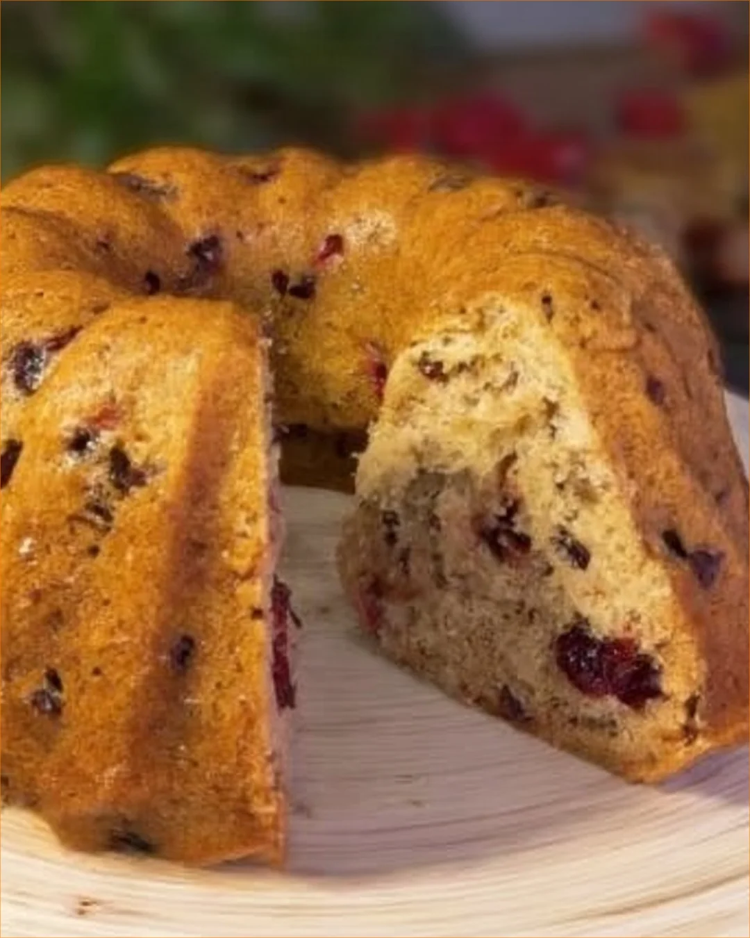 Healthy oatmeal cake with apples and cranberries on a rustic wooden table.