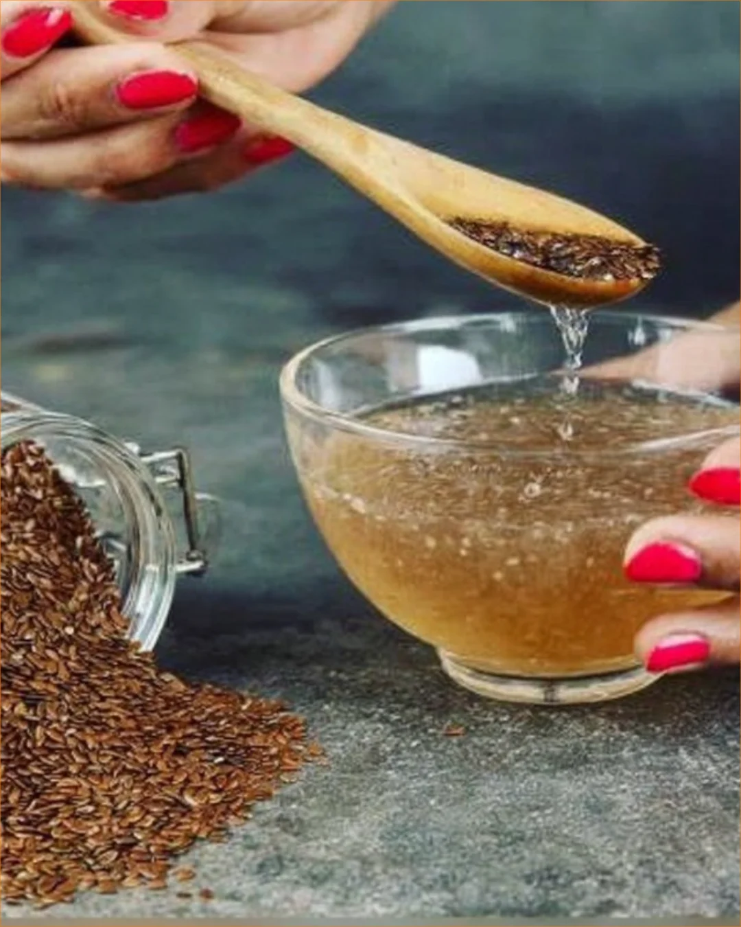 A cup of flaxseed tea with whole flaxseeds on a wooden table.