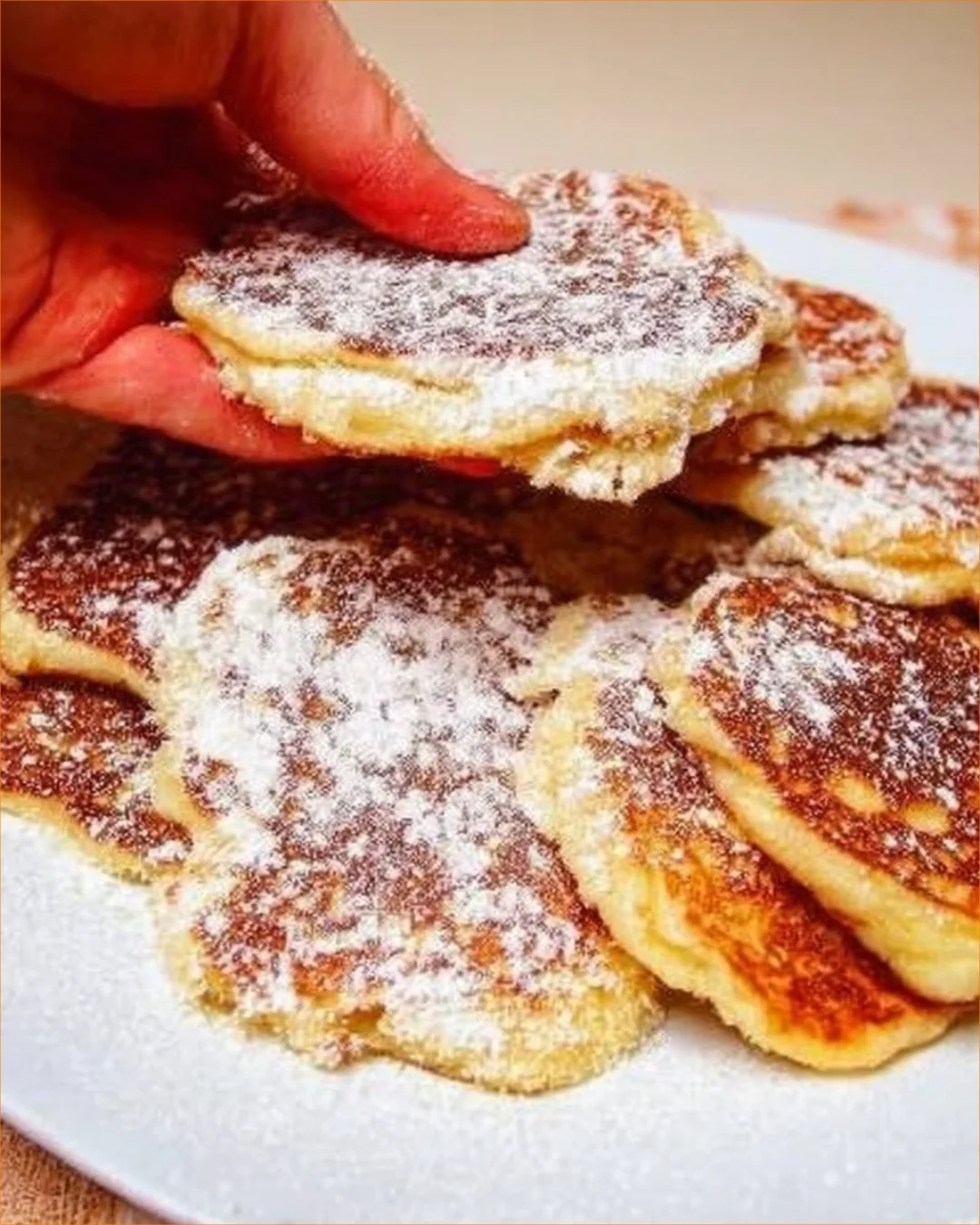 Fluffy apple pancakes topped with fresh fruit and syrup on a plate.
