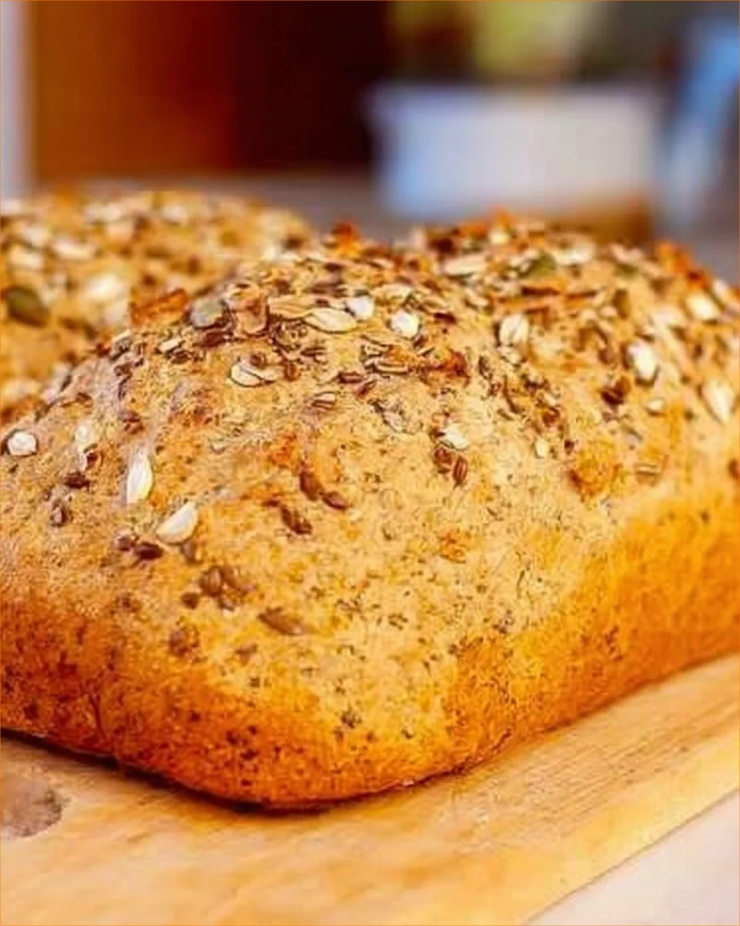 Sliced oatmeal bread with nuts on a wooden cutting board