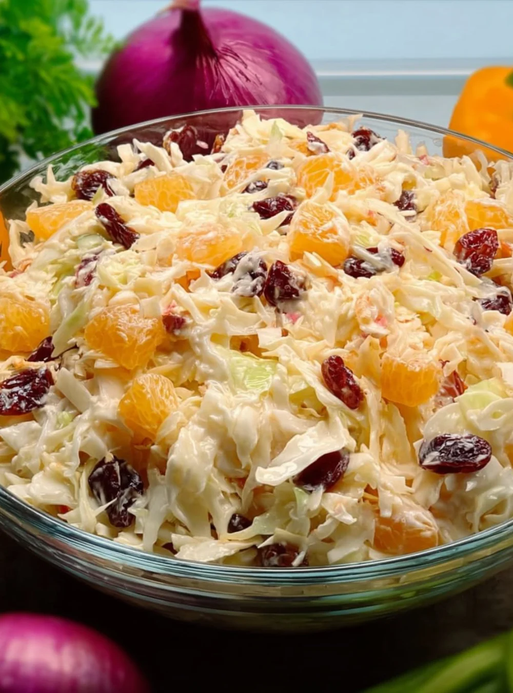 Creamy cabbage salad with pineapple in a bowl, garnished with herbs.