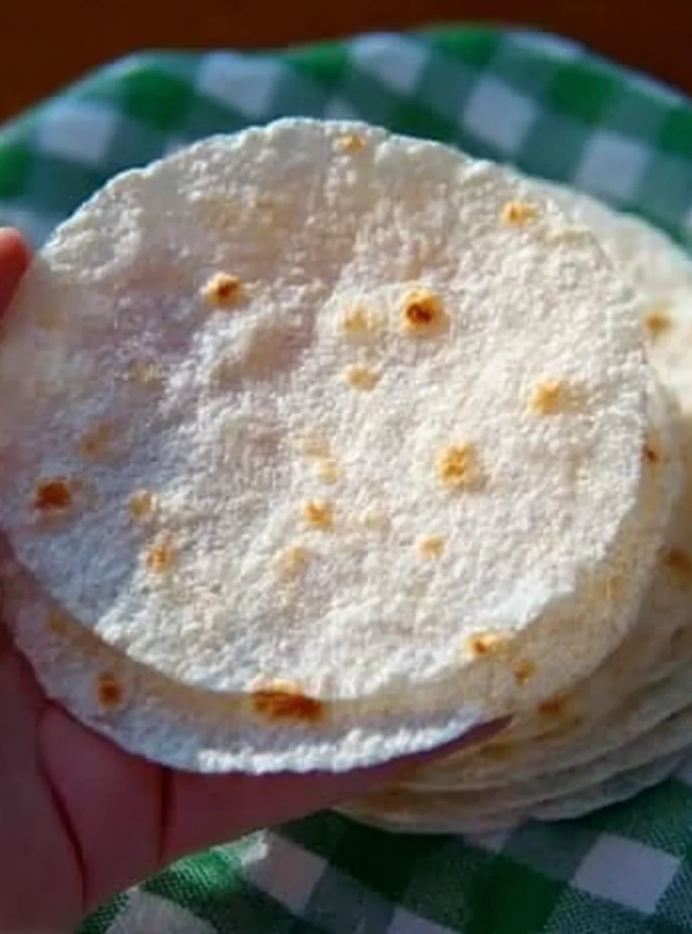 Gluten-free rice tortillas stacked on a wooden board